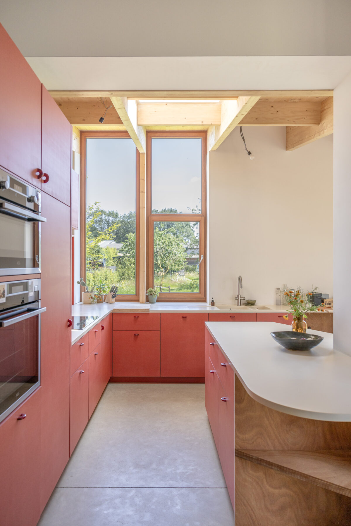 Rode valchromat keuken met zicht op de tuin